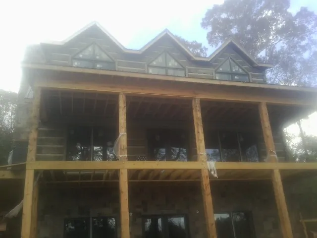Dormers and porch framing on a large log home under construction — Roof Coating work by our crew in Curwensville