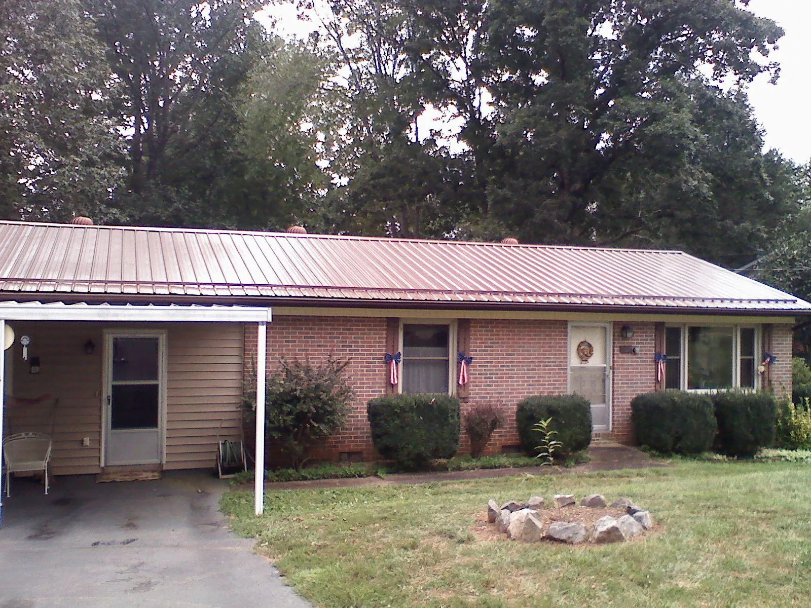 Bronze metal roof and carport on a brick ranch home — Roof Repair work by our crew in Curwensville